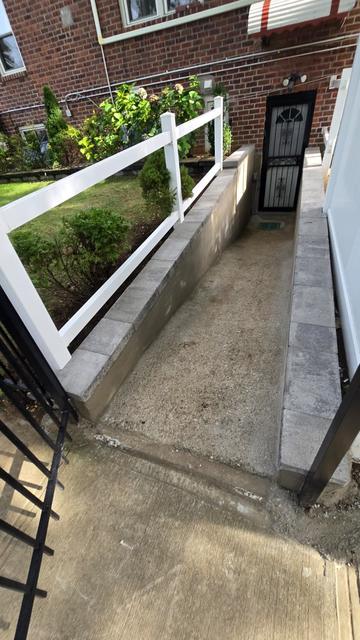 Finished concrete basement entrance with new retaining wall caps and floor at a brick home